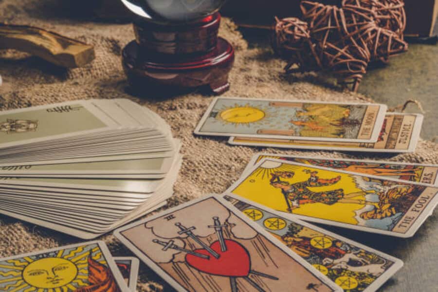 A tarot deck fanned out beside a crystal ball